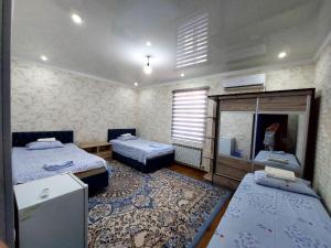 Zimmer mit 2 Betten und einem Spiegel in der Unterkunft Green house in Nukus