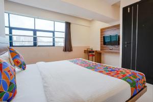 een slaapkamer met een groot bed en een raam bij FabHotel Paradise Inn in Pune