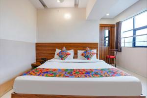een slaapkamer met een groot bed in een kamer bij FabHotel Paradise Inn in Pune