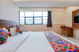 a hotel room with a large bed and a window at FabHotel Paradise Inn in Pune