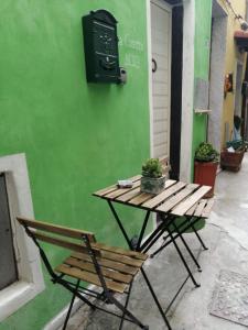 una mesa de picnic y un banco junto a una pared verde en Vezzhouse con Convenzione per Spa & Wellness, en Vezzano Ligure