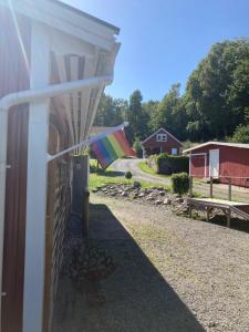 una bandera arco iris colgando del costado de una casa en Stenlid - Med naturen och lugnet i fokus en Veddige