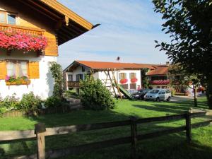 a house with a wooden fence in front of a yard at Ferienwohnungen Rosenegger in Staudach-Egerndach