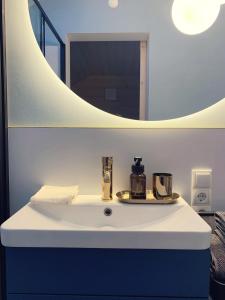 a bathroom with a white sink with a mirror at Homemade Apartment in Liebshausen