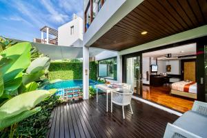 Habitación con balcón, cama y mesa. en The Rock Hua Hin Beachfront Spa Resort, en Hua Hin