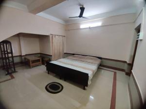 1 dormitorio con 1 cama y ventilador de techo en Madrid Homes, en Guwahati