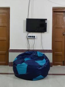 una silla con bolsa de frijoles azules en una habitación con TV en Madrid Homes, en Guwahati