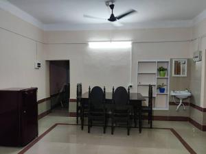 a dining room with a table and chairs and a ceiling fan at Madrid Homes in Guwahati