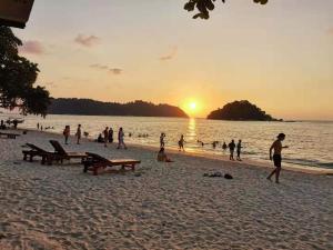 パンコールにあるWalking Distance To The Beach, Pangkorの夕暮れ時の海岸の人々