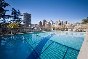a large swimming pool with a city skyline in the background at Sandman Suites Vancouver on Davie in Vancouver