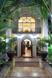 un corridoio con palme in un edificio di Anchor's Rest Guesthouse and Self Catering a Durban