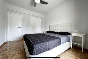 Beach Retreat في فالنسيا: غرفة نوم بسرير ومروحة سقف