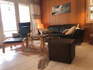 a living room with a black couch and chairs at Residence Edelweiss C311 in Bellwald
