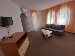 a small living room with a couch and a tv at Guest House Malkata Stopanka in Primorsko