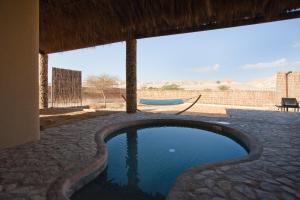 a swimming pool in the middle of a house at Arava Land in Zuqim