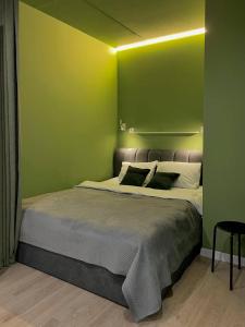 フメリヌィーツィクィイにあるАпартаменти-студія, дизайнерський ремонт, ЦЕНТР, біля ТРК "Либідь Плаза"の緑の壁のベッドルーム1室(大型ベッド1台付)