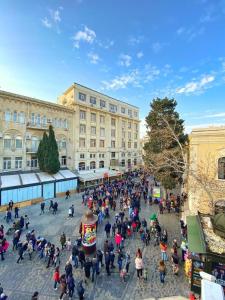 um grande grupo de pessoas em pé em uma praça em frente a um edifício em Center Hotel Baku em Baku