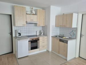 a kitchen with white appliances and wooden cabinets at "Ferienhaus Vadersdorf" Wohnung 1 in Vadersdorf