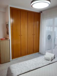 a bedroom with a bed and a large wooden cabinet at Apartment Cambrils Beach and Center in Cambrils