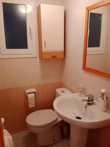a bathroom with a toilet and a sink and a mirror at Apartment Cambrils Beach and Center in Cambrils