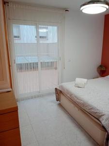 a bedroom with a bed and a large window at Apartment Cambrils Beach and Center in Cambrils