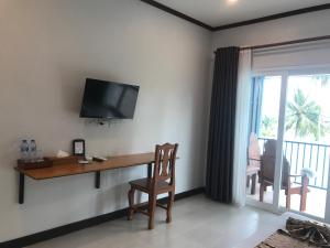 Habitación con escritorio y TV en la pared. en Koh Yao Yai Sea Breeze House เกาะยาวใหญ่ซีบรีซเฮ้าส์ en Ko Yao Yai