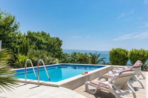 a swimming pool with chaise lounge chairs next to a swimming pool at Holiday Home Split in Split