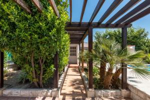 a garden with a pergola and palm trees at Holiday Home Split in Split