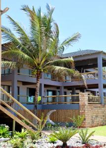 a palm tree in front of a building at Vista do Mar in Inhambane