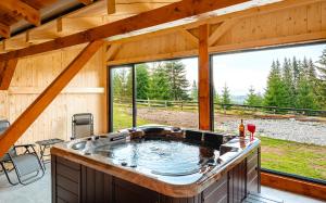 a jacuzzi tub in a cabin with a view at Casa din Deal in Mărişel