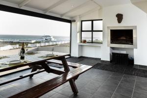comedor con mesa y vistas al océano en Pearl Haven, beach house with magnificent views!, en Yzerfontein