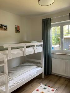 a white bunk bed in a room with a window at Pferdehof Thomayer in Strasswalchen