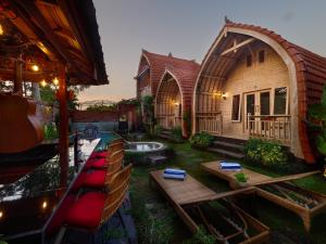 an outdoor patio with chairs and a house at Wisnu Lumbung Uluwatu in Uluwatu