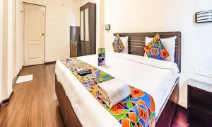 a bedroom with a large bed with a colorful blanket at FabHotel East Field Homes in Pune