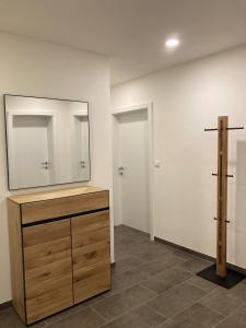 a bathroom with a dresser and a mirror on a wall at Pferdehof Thomayer in Strasswalchen