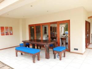 einen Holztisch mit blauen Sitzen sowie einem Tisch und Stühlen in der Unterkunft Imbali Boutique Hotel in Kokstad