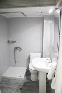 a white bathroom with a toilet and a sink at stuDio57 11 in Alexandroupoli +29 photos