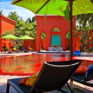 - une piscine avec une chaise et un parasol dans l'établissement The Kiri Villas Resort, à Thalang