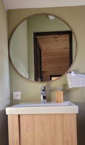 a bathroom with a mirror over a sink at Jvarisa Glamping in Ambrolauri