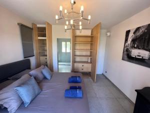 ein Wohnzimmer mit einem Bett und einem Kronleuchter in der Unterkunft Villa familiale avec vue imprenable in Saint-Raphaël