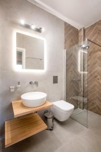 een badkamer met een wastafel, een toilet en een douche bij Nefeli's Apartment in Kardamaina