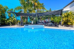una gran piscina con cubierta negra. en Palm Court Motor Inn, en Port Macquarie