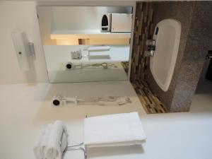 a bathroom with a sink and a toilet with towels at South Hill Motor Inn in Red Deer