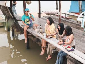 a group of people sitting on a picnic table on a boat at Popole in Nonthaburi
