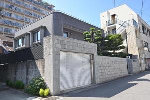 un edificio con una puerta de garaje a un lado en Private Beppu Tanoyu Onsen, en Beppu