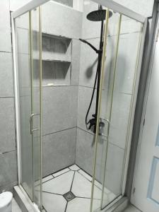 a shower with a glass door in a bathroom at La Rêverie Apartment in Trou aux Biches