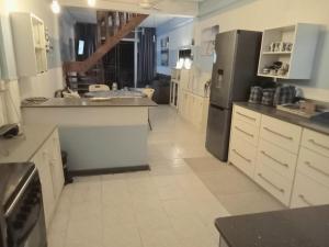 a large kitchen with white cabinets and stainless steel appliances at La Rêverie Apartment in Trou aux Biches