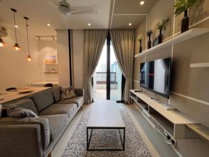 a living room with a couch and a tv at ARCORIS, MONT KIARA by MK HOME in Kuala Lumpur