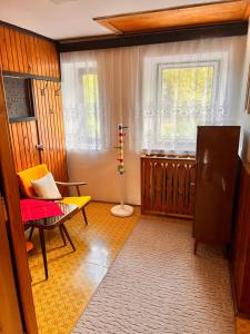 sala de estar con silla y ventana en Na samotě u lesa, en Loučovice