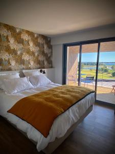 a bedroom with a large bed and a balcony at La Bellevue Bistrot et Chambres d'Hotes in Séné